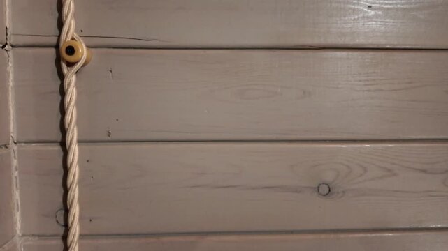 Retro-style double electrical socket and twisted fabric wire installed on a painted wooden plank wall. Old-fashioned home interior wiring
