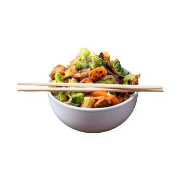 Asian style stir-fry of chicken pieces, broccoli, sliced carrots, and baby corn, with a pair of wooden chopsticks. Asian food, takeout food, healthy dinner, lunch bowl, savory meal.