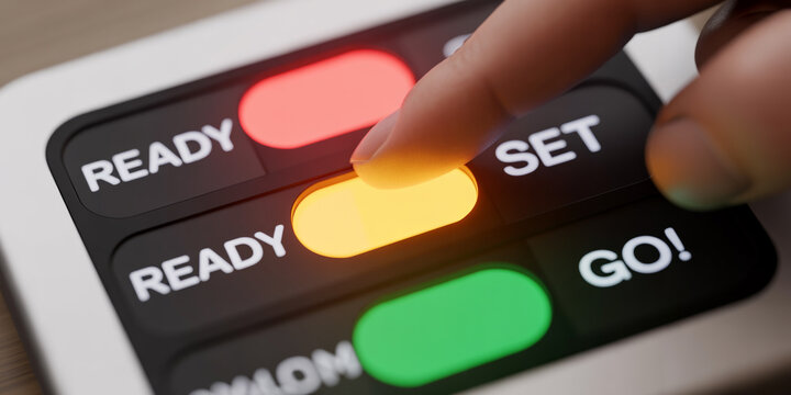 Finger pressing a glowing yellow set button on a black control panel with ready and go labels