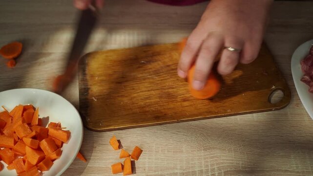 Man grates carrot on stainless steel grater