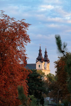 Stunning cathedral spires rising above vibrant autumn foliage in a peaceful city landscape