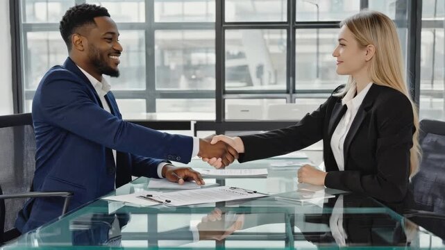 Professional Business Partners Shaking Hands Over a Contract in Modern Office