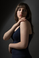Fototapeta premium Portrait of a beautiful teenage girl posing in dark studio