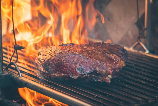 Grilled steak cooking over an open flame