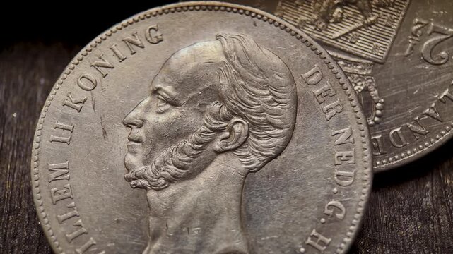 Close-up video of a historic Dutch 2.5 gulden silver coin featuring the portrait of Willem II. The footage highlights the engraved profile, and classic numismatic character of the collectible coin.