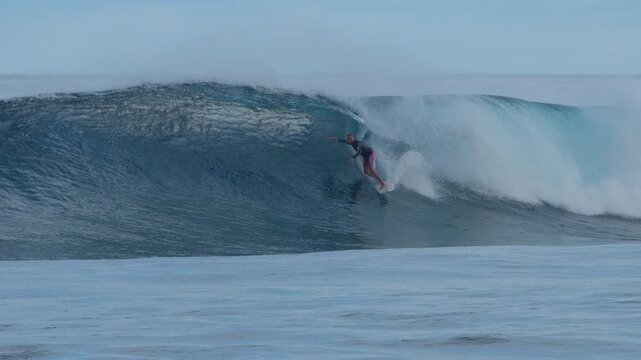 Person surfs perfect ocean wave on the Sultans surfing spot in the Maldives