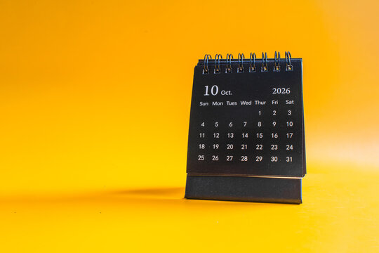 Desktop calendar showing October 2026 on yellow background, time management and planning concept