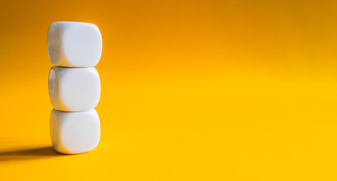 White blocks balanced in tower stack on yellow banner background