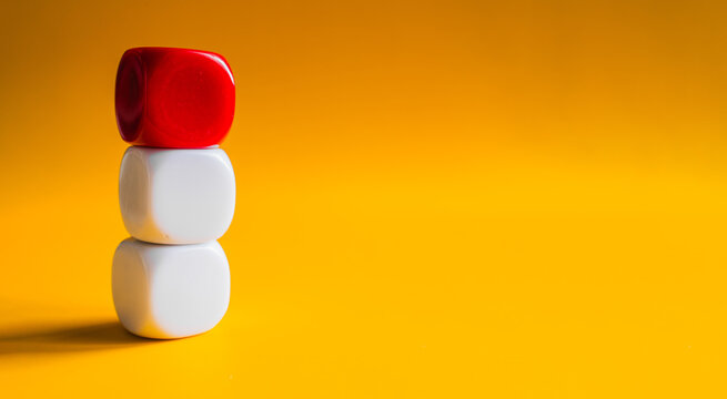 White and red blocks balanced in tower stack on yellow banner background