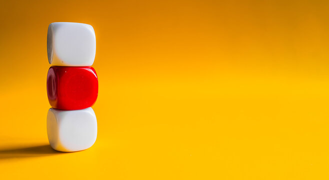 White and red blocks balanced in tower stack on yellow banner background