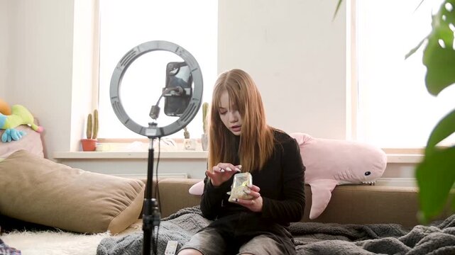 Young Woman Recording Video Blog with Smartphone and Ring Light in Living Room