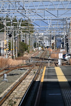 鉄道の線路と架線柱が続くプラットホームからの風景