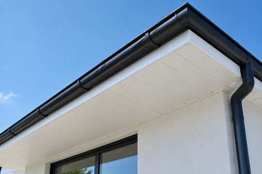 Clean white soffit board under eaves contrasting with dark rain gutter.
