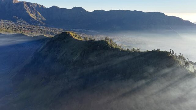 Mist swallows valleys, wraps peaks in silence. Sunlight pierces clouds near Bromo