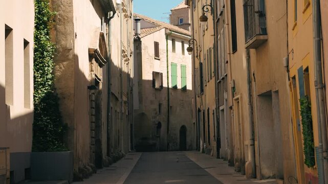 Quiet narrow street in a historic European old town with traditional stone buildings in warm afternoon sunlight. Empty medieval alley showcasing authentic architecture and peaceful urban atmosphere.