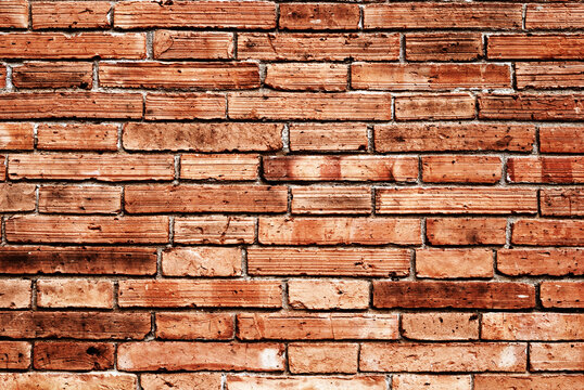 Red brick wall texture background with uneven horizontal mortar layers