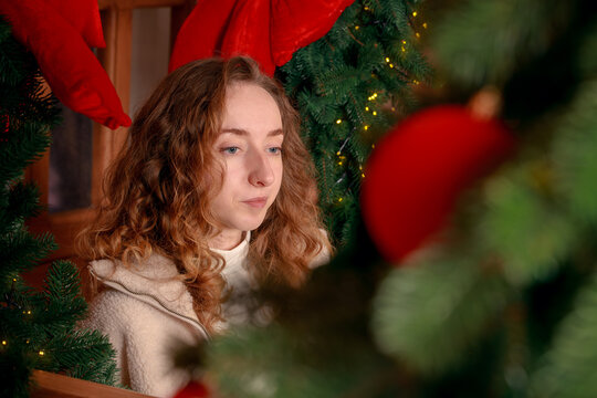 Candid portrait of a young woman with curly hair in a festive Christmas decorated interior space
