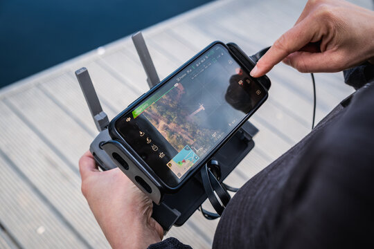 Opole, Poland - November 1, 2022: Close-up of a drone pilot's hands operating a remote controller during an outdoor flight.