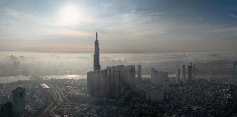Fototapeta premium Landmark 81 and city towers silhouetted in bright haze, Ho Chi Minh City, Vietnam