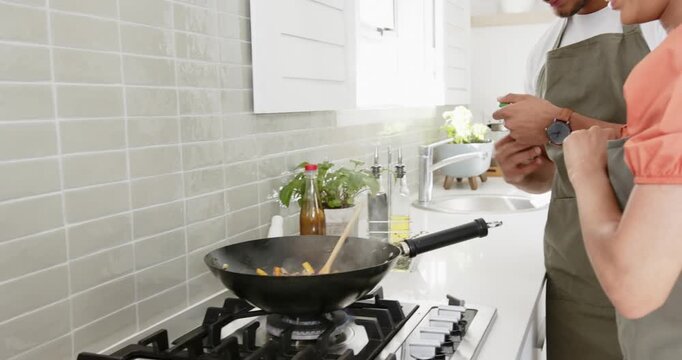 Lifestyle videos indoor of people doing activities at home, cooking together, couple adding spices t