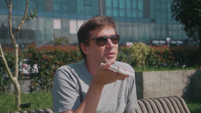 Audio message recording for direct messaging, man speaks into smartphone during online chat and modern digital communication outdoors.