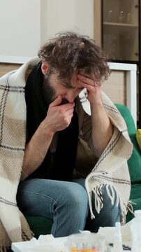 Vertical video. Man coughing and while getting sick and taking cure at home. Concept of healthcare and illness.