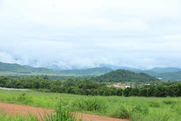 Fototapeta premium Green hills and mountains under cloudy sky