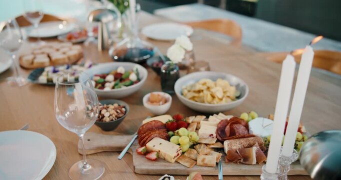 Party, food or charcuterie board on table with candles, sushi arrangement or meal setup at gathering. Celebration, nutrition or catering with platter, appetizer or snack selection in outdoor event.
