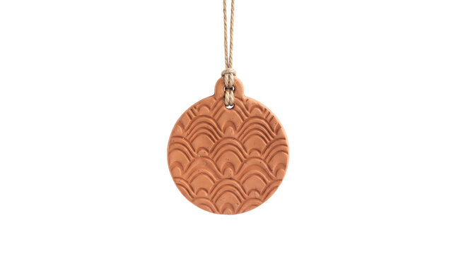 Handmade terracotta ornament with scale pattern hanging from twine isolated on transparent background