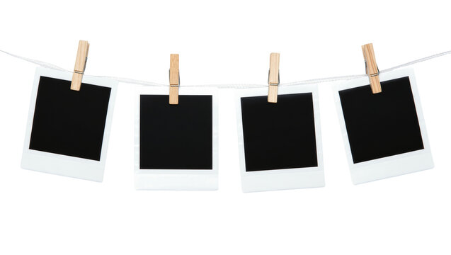 Four blank instant photo prints with wooden clothespins on a string, isolated on transparent background