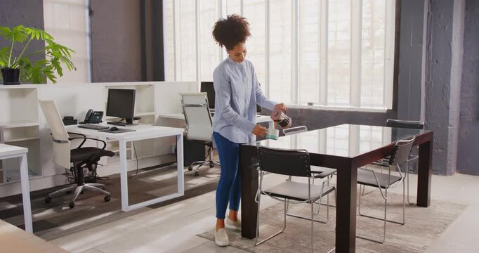 Businesswoman enjoying coffee break standing in modern office with natural light
