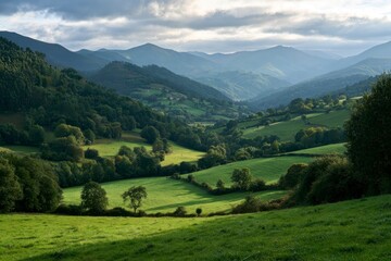 Fototapeta premium Scenic landscape of lush green valleys and rolling hills under a mountain range in northern Spain
