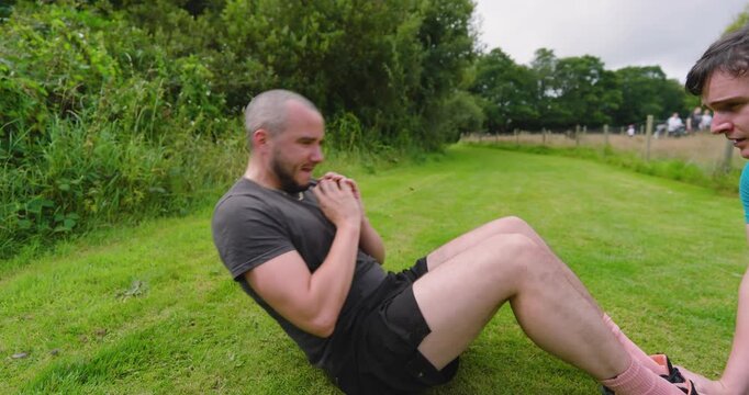 Man resting on grass after jogging in park, enjoying peaceful nature