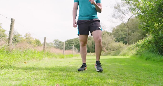 Man jogging on grassy path in park, enjoying outdoor exercise