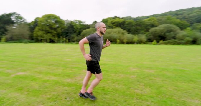 Man jogging on green field, enjoying outdoor exercise and fresh air