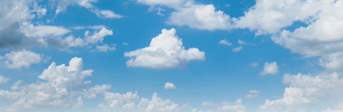 Blue sky stretches wide with fluffy white clouds