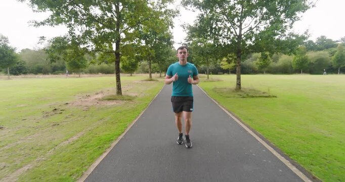 Man jogging on park path, enjoying outdoor exercise and fresh air