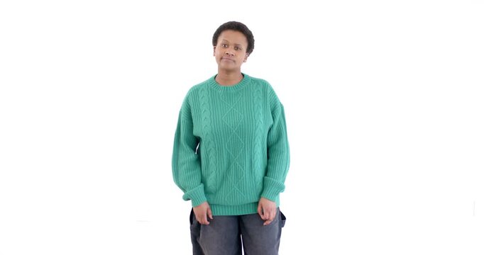 Standing confidently against white background, person in green sweater looking thoughtful