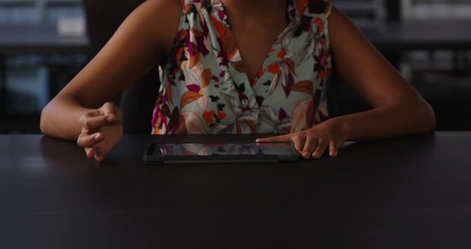 Businesswoman using tablet at office desk, focusing on digital work