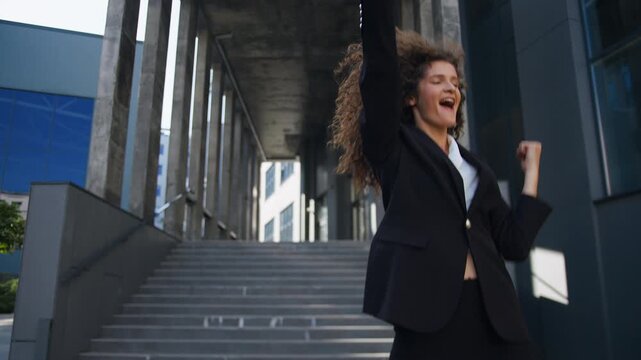 Happy Caucasian business woman intern candidate get new job celebrating successful work results winning walking down stairs in city jump leaving office businesswoman female girl win celebrate jumping