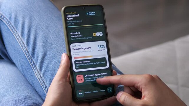 Person reviews household pantry levels and a grooming appointment on a smartphone, highlighting shared pet care, supply planning and organized daily routines.