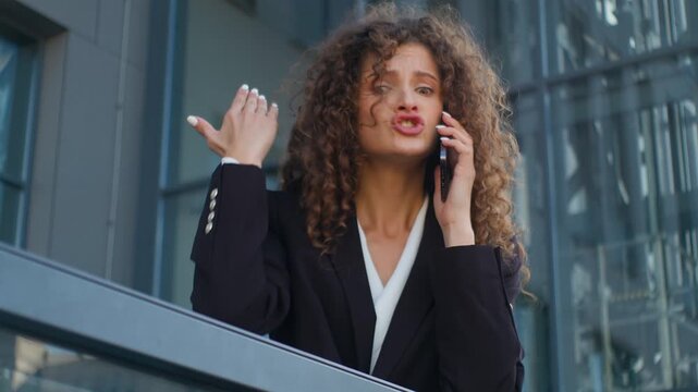 Emotional furious Caucasian business woman yelling talking conflict with mobile phone misunderstanding disagreement communication problem businesswoman angry talk female girl on office balcony in city