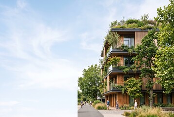 Obraz premium A modern building stands in an urban setting. It features green plants on levels and wooden elements. People walk nearby, enjoying the city