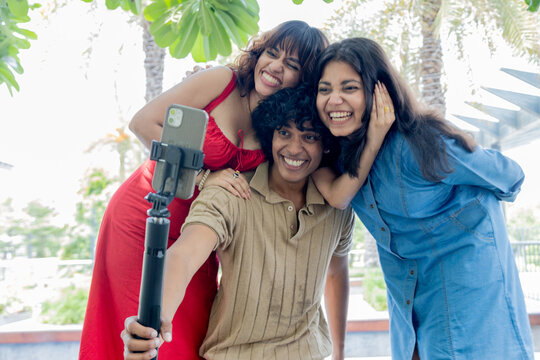 Young Indian Gen Z friends taking fun selfies together outdoors, smiling and posing for the camera, representing friendship, social media, youth culture, digital lifestyle and modern urban life.