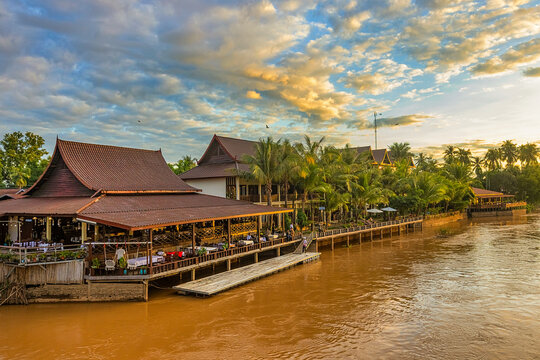 Sunset over the Mekong River at the Historic Don Det&ndash;Don Khon Bridge, Khong District, Champasak Province, Laos, with tourists enjoying the view and locals crossing the historic landmark.