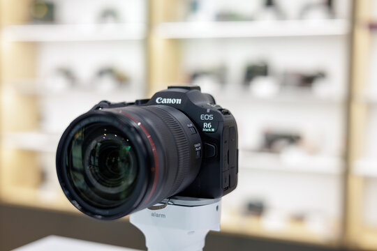 Poznan, Poland - April 14, 2026: Close-up view of Canon EOS R6 Mark III mirrorless camera with professional RF zoom lens on display stand inside Cyfrowe new photo store.