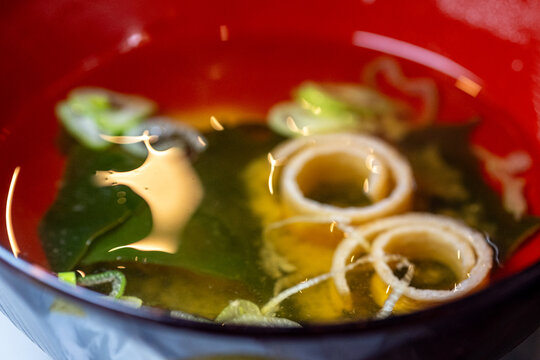 Traditional Japanese miso soup served in a red lacquer bowl.