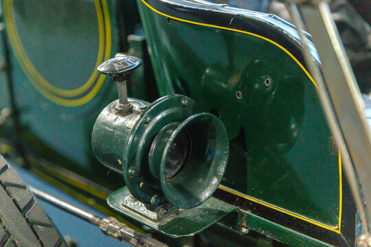 Vintage car horn with mechanical pull handle

Close‑up of a vintage car horn mounted on the side of a classic vehicle. The metal horn features a pull handle mechanism and is integrated into the car&rsquo;s 