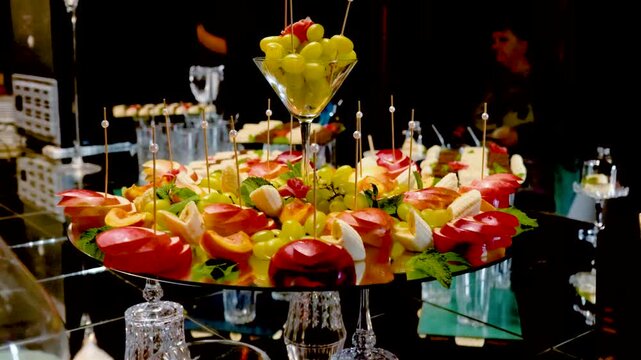 Fruits, cakes, and sweets on a festive banquet table before a business event or other celebration. Sweet drinks for guests.