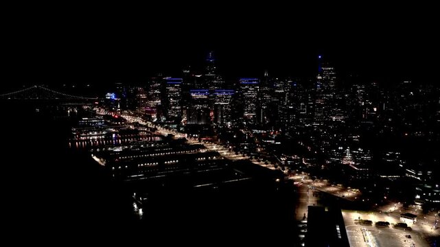 Aerial View Of San Francisco Waterfront At Night With Bay Bridge And Downtown Buildings